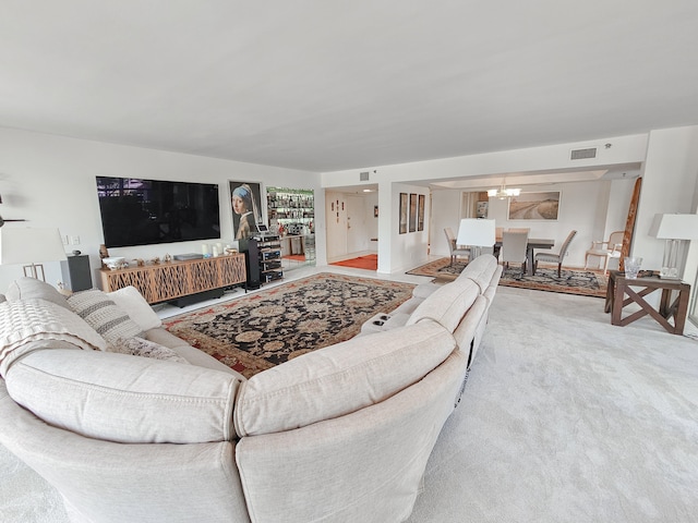 living room with light carpet and a chandelier