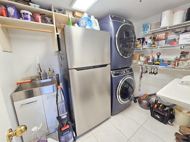 laundry room with stacked washer / drying machine and light tile patterned floors