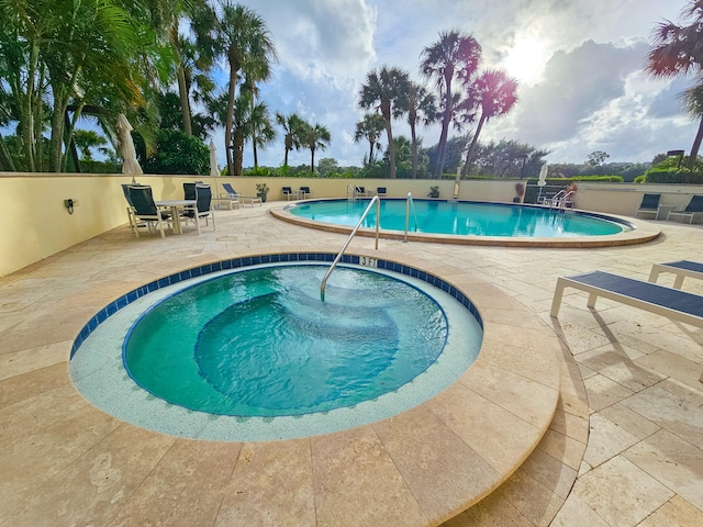 view of pool featuring a community hot tub and a patio