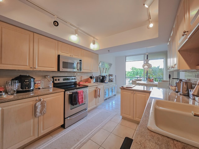 kitchen featuring backsplash, stainless steel appliances, sink, light tile patterned floors, and hanging light fixtures