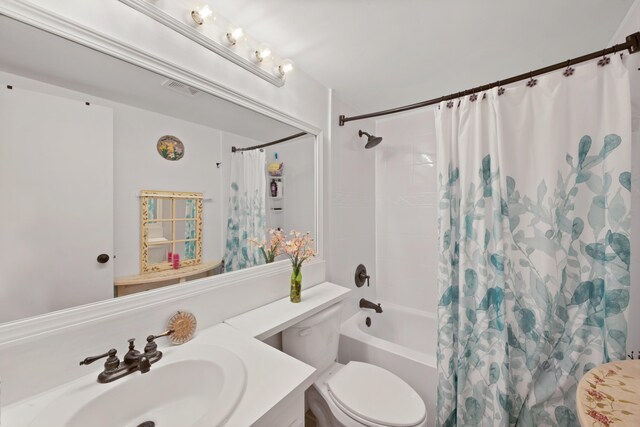 full bathroom featuring shower / bath combination with curtain, toilet, and vanity