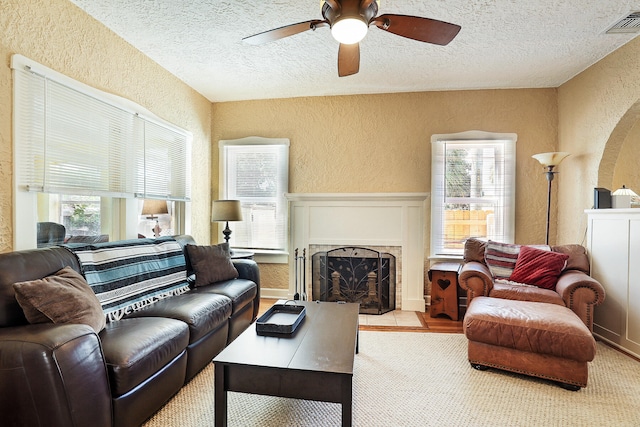 living room featuring ceiling fan and a textured ceiling