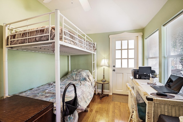 bedroom with vaulted ceiling, light hardwood / wood-style flooring, multiple windows, and ceiling fan