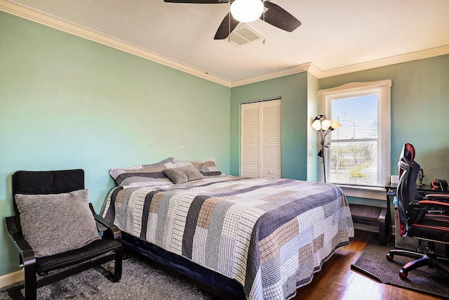 bedroom featuring dark hardwood / wood-style flooring, a closet, crown molding, and ceiling fan