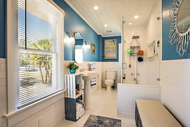 bathroom featuring tile patterned floors, walk in shower, ornamental molding, tile walls, and toilet