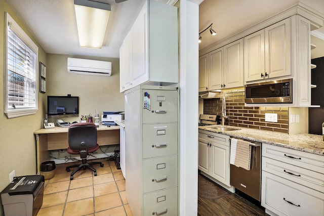 kitchen with sink, stainless steel appliances, light stone counters, backsplash, and a wall mounted AC