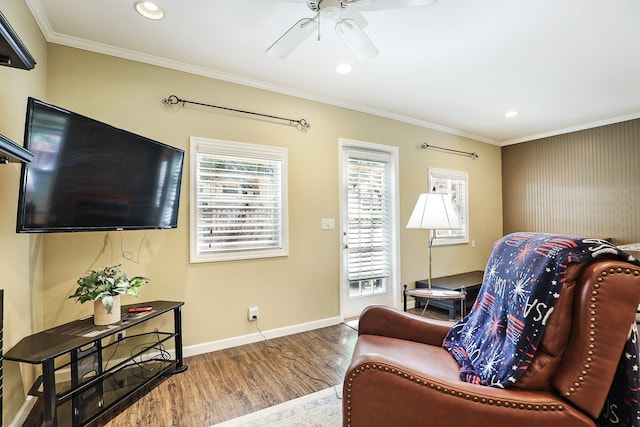 living room featuring hardwood / wood-style flooring, ceiling fan, and crown molding