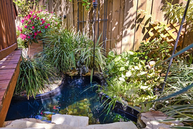 view of yard featuring a garden pond and a swimming pool