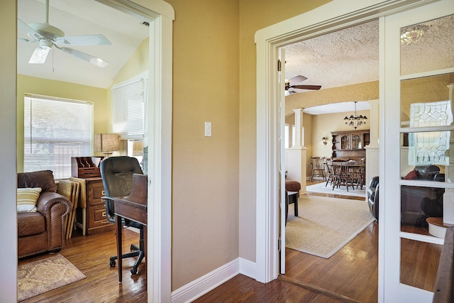 office area with hardwood / wood-style flooring, ceiling fan with notable chandelier, a textured ceiling, and vaulted ceiling