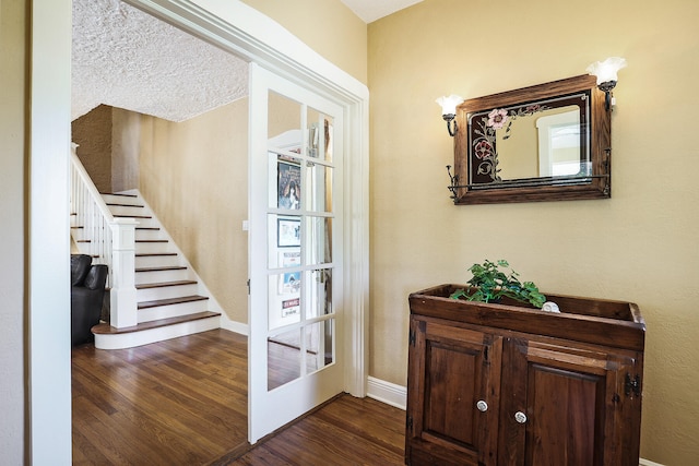 entrance foyer with a textured ceiling and dark wood-type flooring