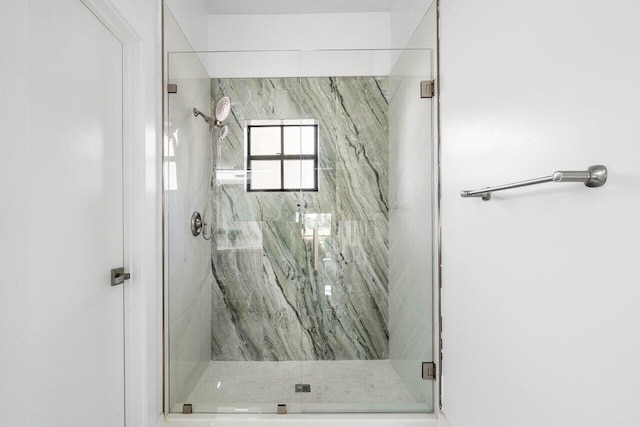 bathroom featuring a shower with door