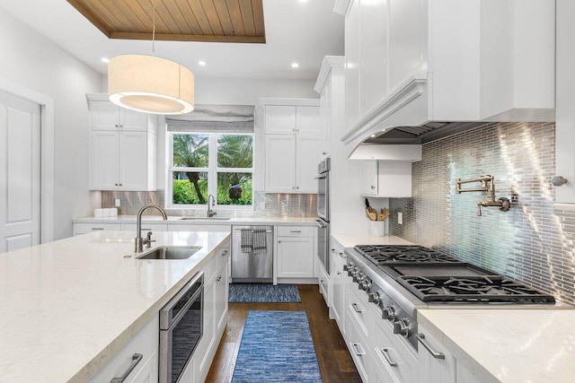 kitchen featuring decorative backsplash, sink, stainless steel appliances, and decorative light fixtures