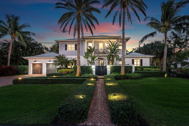 mediterranean / spanish-style home with a yard, a balcony, and a garage