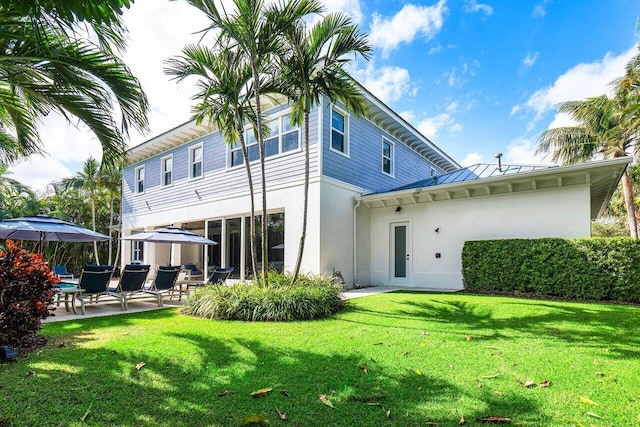 back of property featuring a patio area and a yard