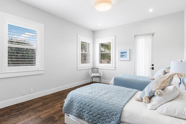 bedroom with multiple windows and dark wood-type flooring