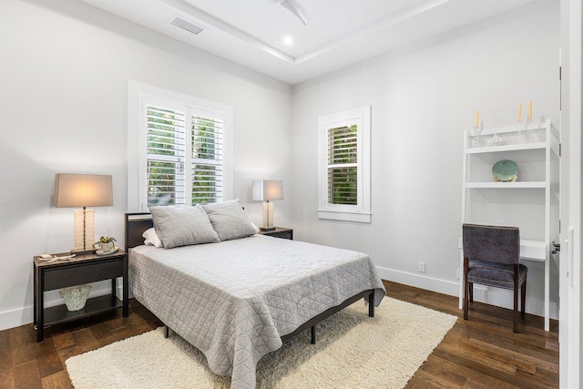 bedroom with dark hardwood / wood-style flooring and ceiling fan