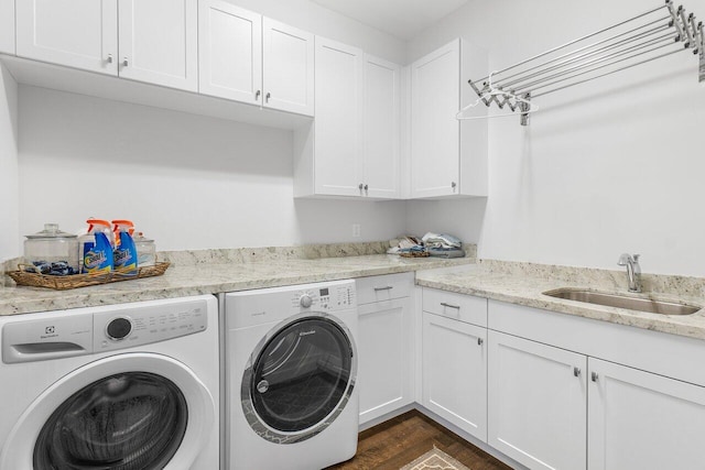 washroom with dark hardwood / wood-style floors, cabinets, sink, and washing machine and clothes dryer