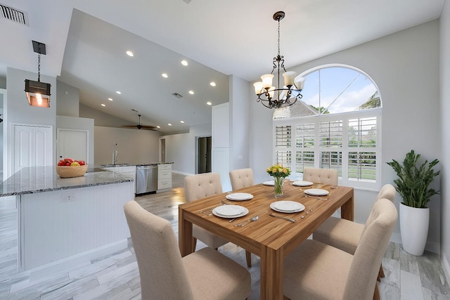 dining space with light wood-type flooring, a chandelier, sink, and lofted ceiling