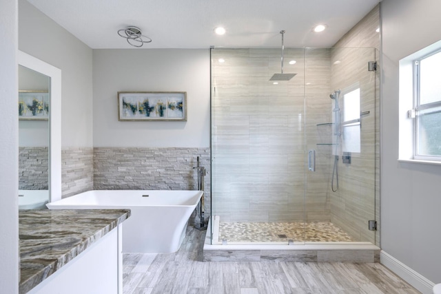 bathroom with vanity, tile walls, and separate shower and tub