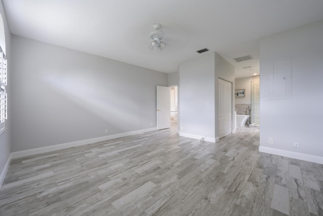 empty room with ceiling fan and light hardwood / wood-style floors