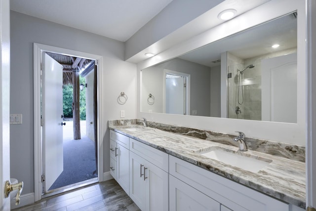 bathroom with a shower with shower door and vanity