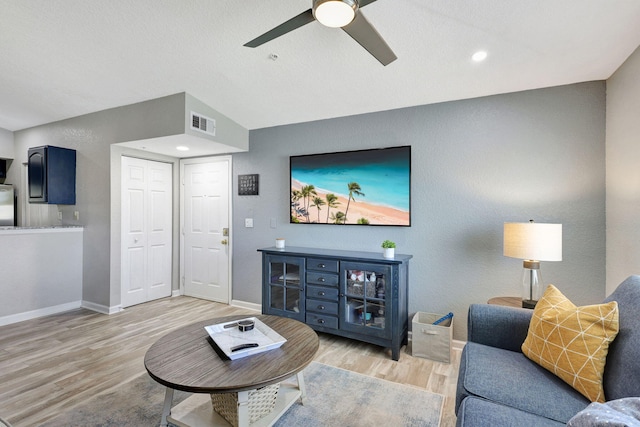 living room with light hardwood / wood-style flooring, ceiling fan, and lofted ceiling