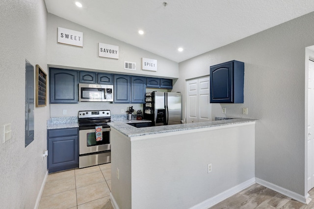 kitchen featuring kitchen peninsula, blue cabinets, lofted ceiling, and appliances with stainless steel finishes