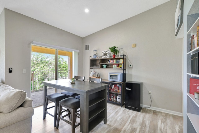 dining area featuring light hardwood / wood-style floors and lofted ceiling