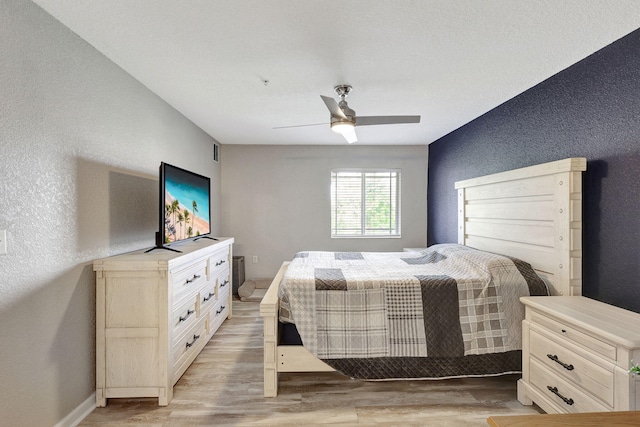 bedroom with light hardwood / wood-style flooring and ceiling fan