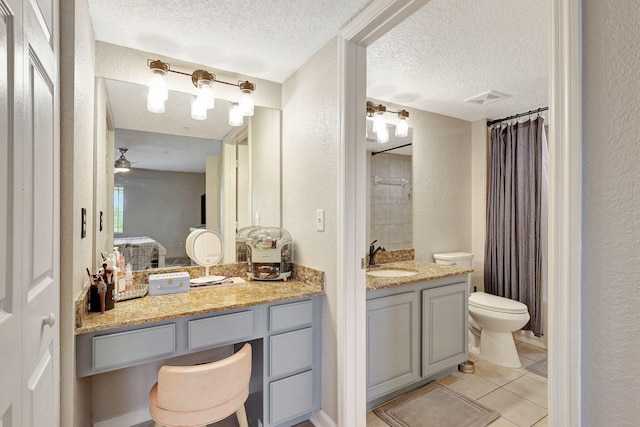 bathroom featuring tile patterned floors, vanity, a textured ceiling, ceiling fan, and toilet