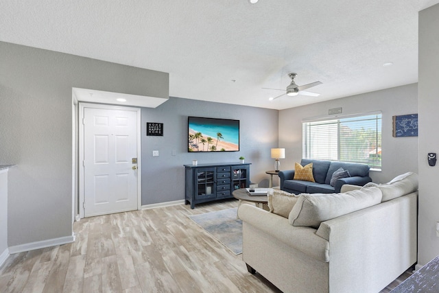 living room featuring a textured ceiling, light hardwood / wood-style floors, and ceiling fan