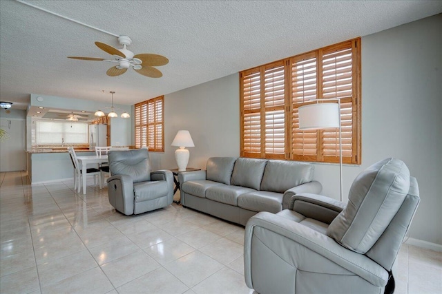 tiled living room with ceiling fan and a textured ceiling