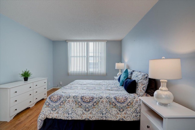 bedroom with light hardwood / wood-style floors and a textured ceiling