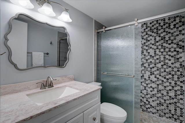 bathroom with vanity, toilet, and a shower with door