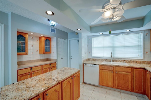 kitchen featuring ceiling fan, sink, light stone counters, white dishwasher, and light tile patterned floors