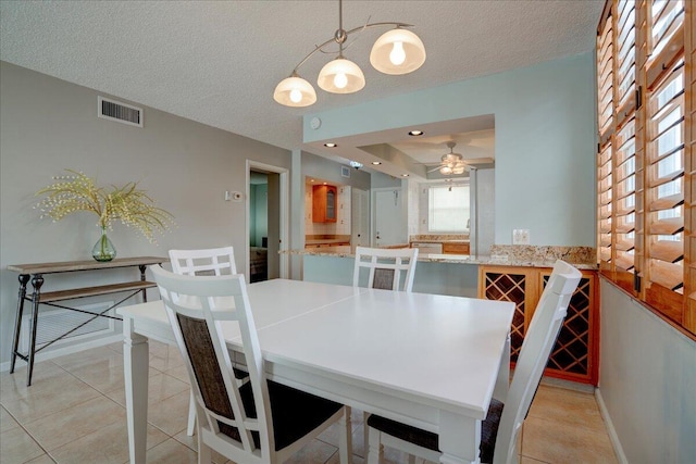 dining room with ceiling fan, light tile patterned floors, and a textured ceiling