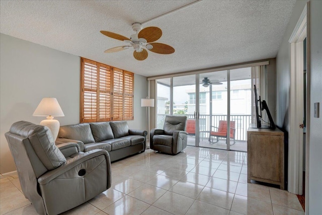 living room featuring expansive windows, ceiling fan, light tile patterned floors, and a textured ceiling