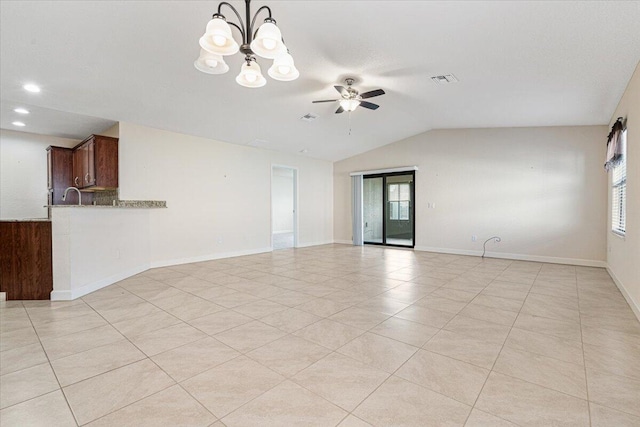 unfurnished room featuring ceiling fan with notable chandelier, vaulted ceiling, plenty of natural light, and light tile patterned flooring