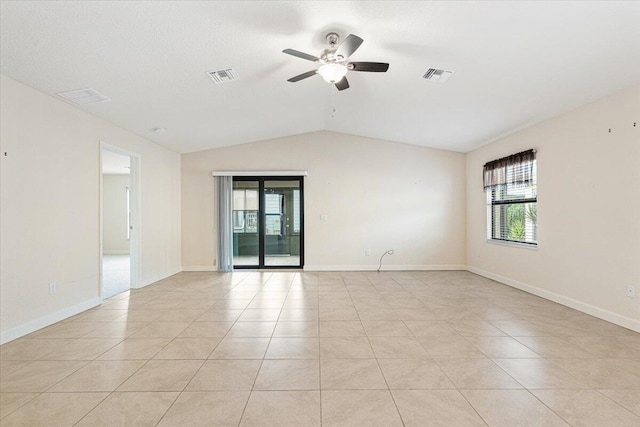 spare room with ceiling fan, plenty of natural light, light tile patterned floors, and lofted ceiling