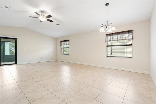 empty room featuring ceiling fan with notable chandelier, light tile patterned flooring, and vaulted ceiling