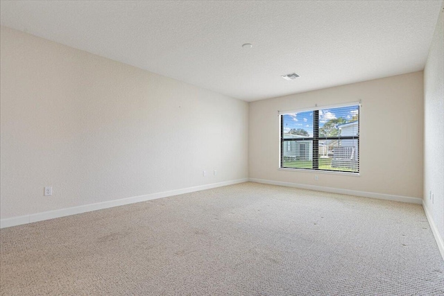 carpeted spare room with a textured ceiling