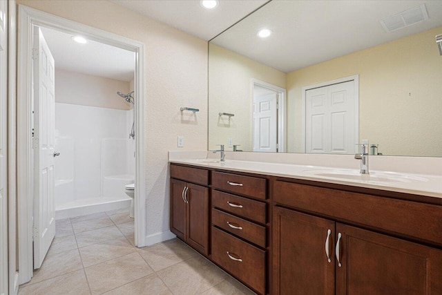 bathroom with tile patterned floors, walk in shower, vanity, and toilet