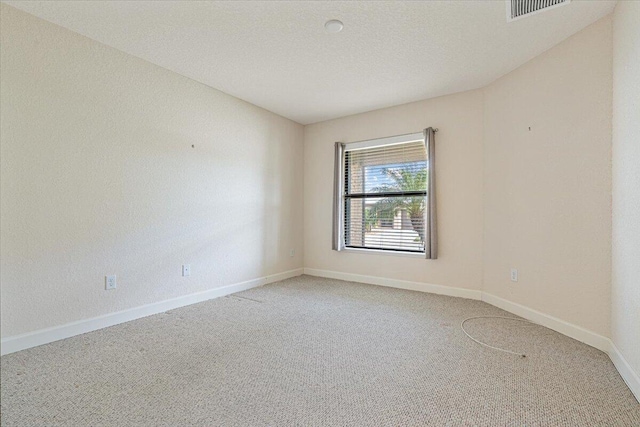 carpeted empty room with a textured ceiling