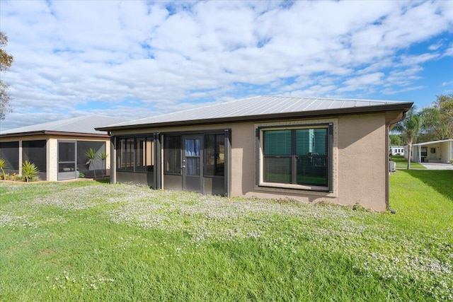 rear view of property with a sunroom and a yard