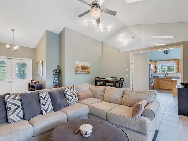 tiled living room featuring ceiling fan, sink, high vaulted ceiling, and french doors