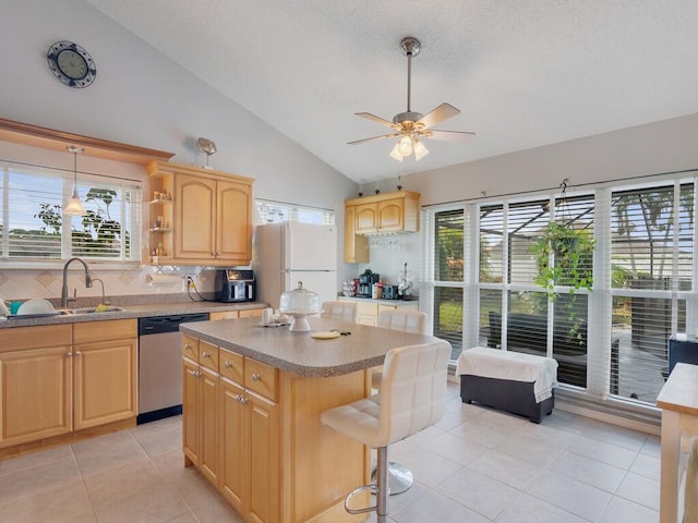 kitchen featuring dishwasher, white refrigerator, lofted ceiling, light brown cabinetry, and a kitchen island