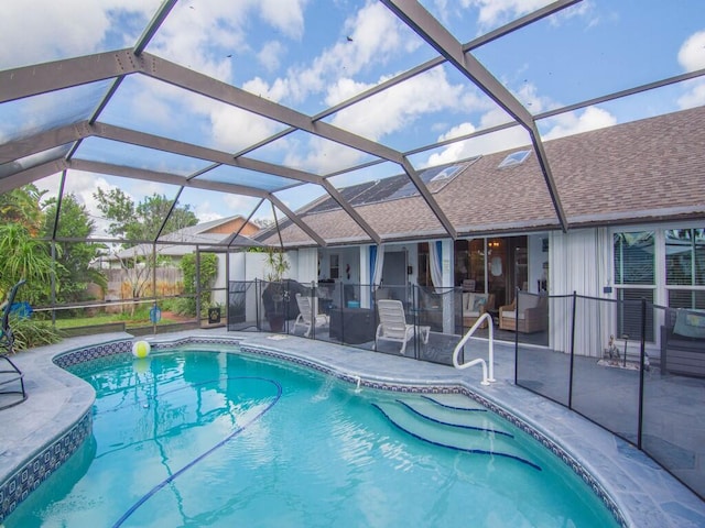 view of swimming pool featuring glass enclosure and a patio