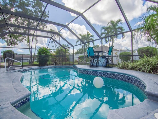 view of swimming pool featuring a patio and a lanai