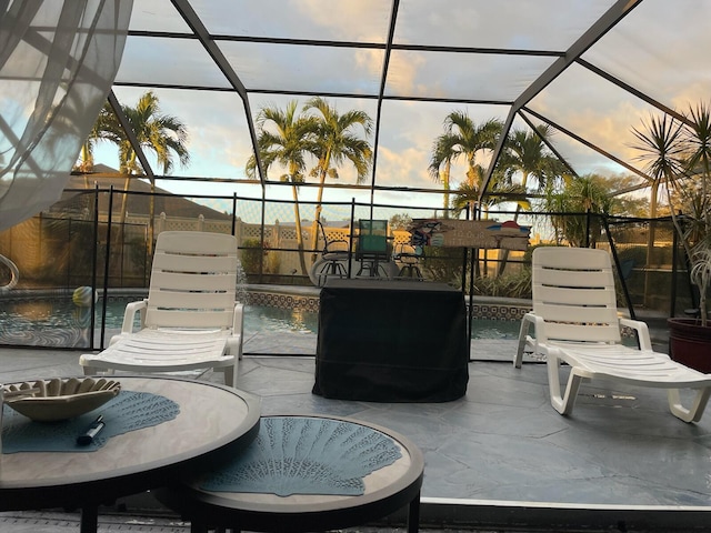 patio terrace at dusk featuring pool water feature and glass enclosure