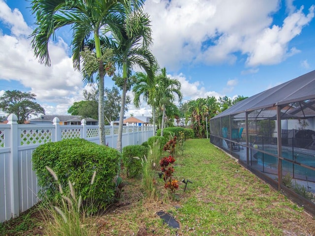 view of yard featuring glass enclosure and a fenced in pool